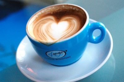 latte in blue cup with heart shaped foam